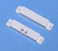 White surface mount magnetic alarm contact sensor with two rectangular components showing mounting brackets and contact poin…
